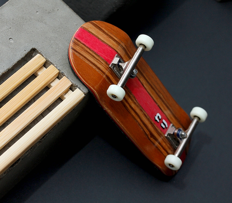 Splitply fingerboard deck from Kali Fingerboards, set up with Blackriver Trucks and Joycult Wheels on a concrete and wood bench